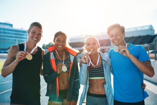 Athletes pose with their medals after winning